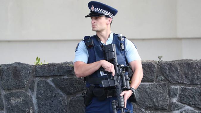 An armed police officer stands guard in Greenlane. (Photo / Jason Oxenham)
