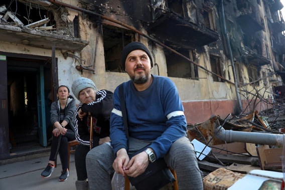 Local residents sit in front of a damaged apartment building from heavy fighting in an area controlled by Russian-backed separatist forces in Mariupol, Ukraine. (Photo / AP)