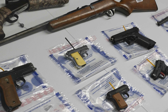 A collection of illegal guns is displayed during a gun buyback event in New York. Photo / AP