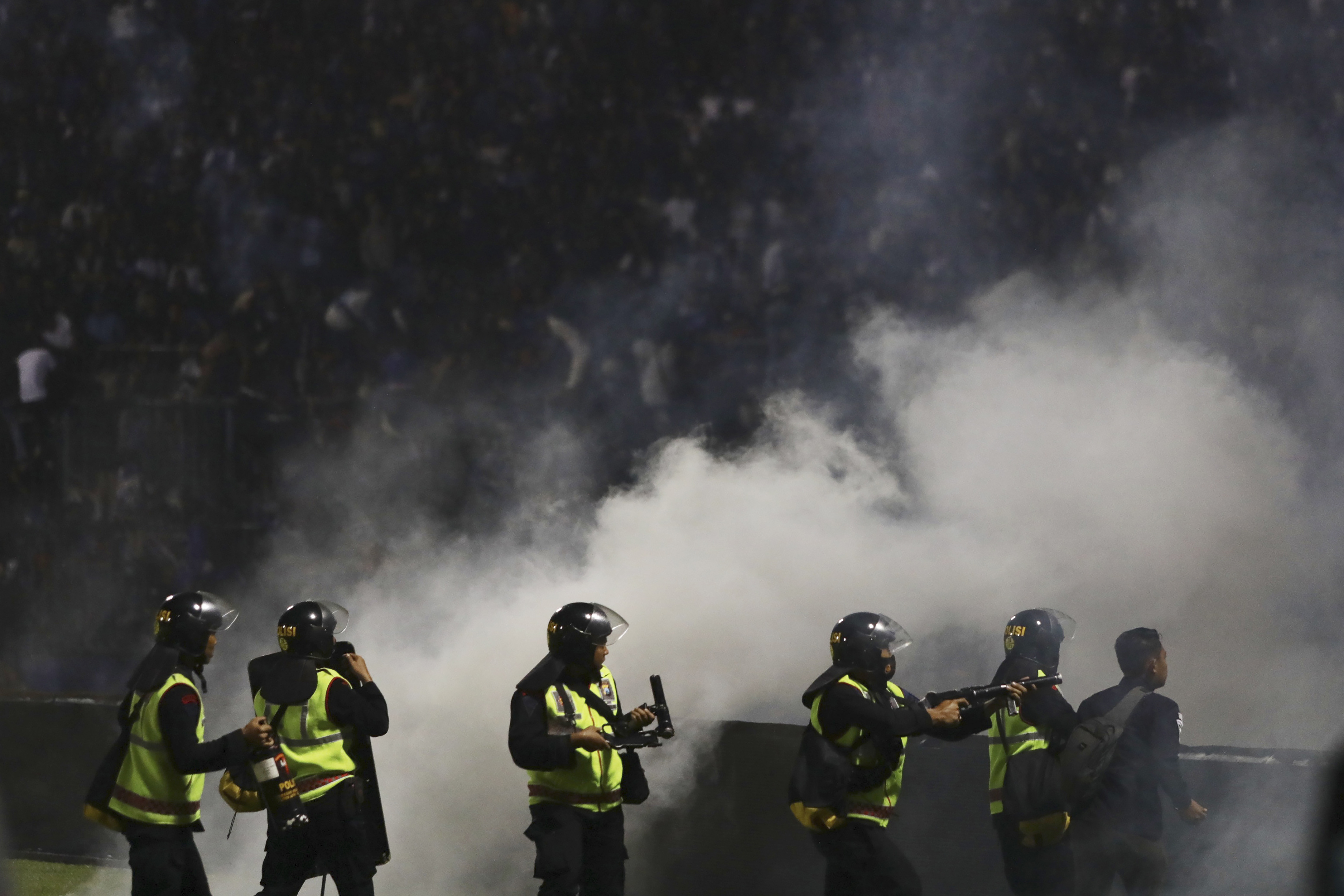 Police officers fire tear gas during clashes between fans at a soccer match at Kanjuruhan Stadium in Malang, East Java, Indonesia. Photo / AP