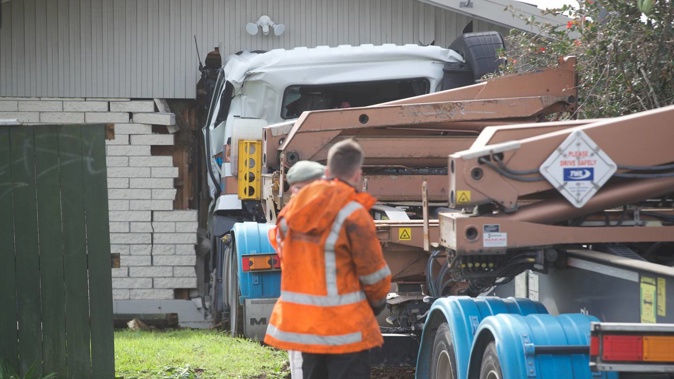 A truck carrying a crane crashed through a fence and into a house at the intersection of Waipuna Rd and Carbine Rd in Mount Wellington, Auckland. Photo / Jason Oxenham