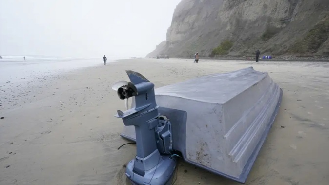 A boat sits overturned on Blacks Beach. Photo / AP