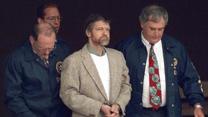 Theodore Kaczynski looks around as US Marshals prepare to take him down the steps at the federal courthouse to a waiting vehicle in 1996. He has died aged 81. Photo / AP File