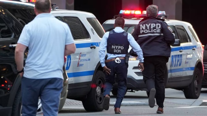 New York Police Department officers on the move as part of the response to the shootings in the Midtown Manhattan neighbourhood. Photo / Timothy A. Clary, AFP