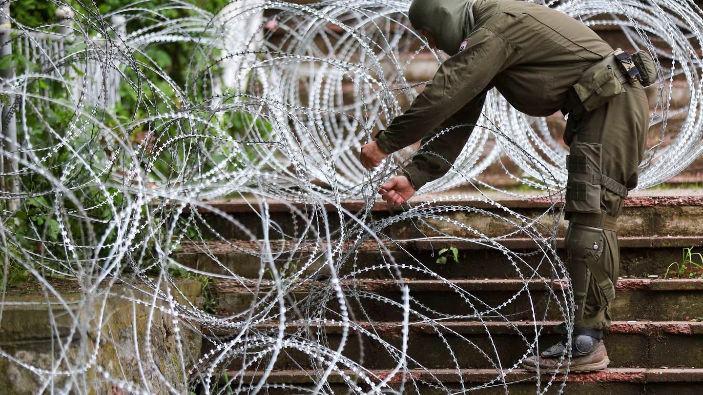KFOR soldiers place barbed wire in front of the city hall in the town of Zvecan, northern Kosovo. Photo / AP