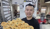 Pakuranga Bakery manager Pho Bok with a tray full of lo'i hossi pies. Photo / RNZ, Ross McNaughton