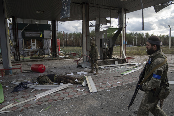 Ukrainian servicemen find a body of their comrade on the destroyed petrol station in the recently recaptured town of Lyman, Ukraine. Photo / AP