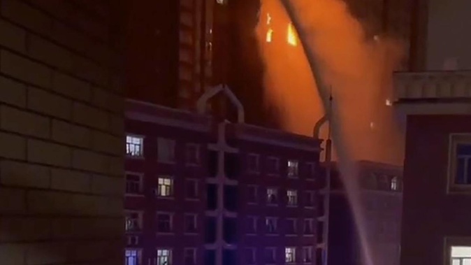 Firefighters spray water on a fire at a residential building in Urumqi in western China's Xinjiang Uyghur Autonomous Region. Photo / AP