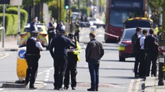 Police talking to members of the public at the scene in Hainault, north east London, Tuesday, April 30, 2024 after reports of several people being stabbed at a Tube station. (Jordan Pettitt/PA via AP)