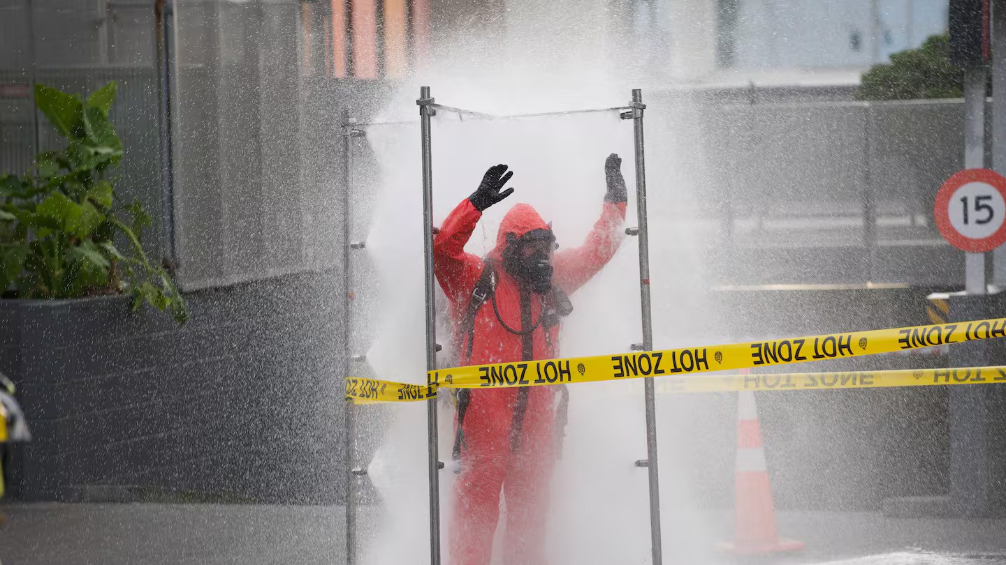A Hazmat fire crew member being decontaminated in central Auckland. Photo / Jason Dorday