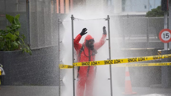 A Hazmat fire crew member being decontaminated in central Auckland. Photo / Jason Dorday