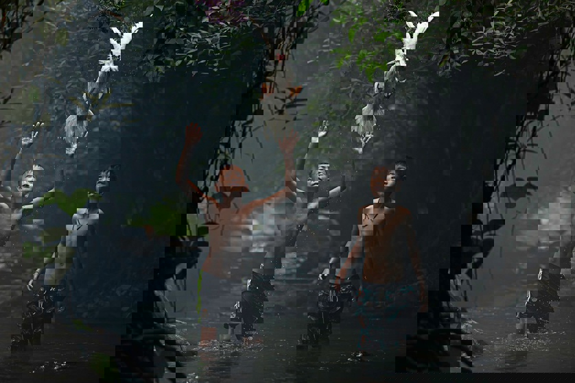 Two boys trying to catch a duck at the stream of the waterfall in Nong Khai province, Thailand (Sarah Wouters)