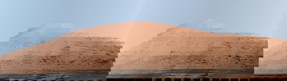 This mosaic of images shows Mount Sharp. White-balanced color adjustment has made the sky look overly blue but shows the terrain as if under Earth-like lighting.