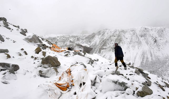 Photograph taken on April 25, 2015: Expedition guide Pasang Sherpa runs towards flattened tents in search of survivors after an avalanche that flattened parts of Everest Base Camp (Getty Images) 