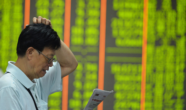 An investor watches the electronic board at a stock exchange hall on August 24, 2015 in Hangzhou, China (Getty Images) 