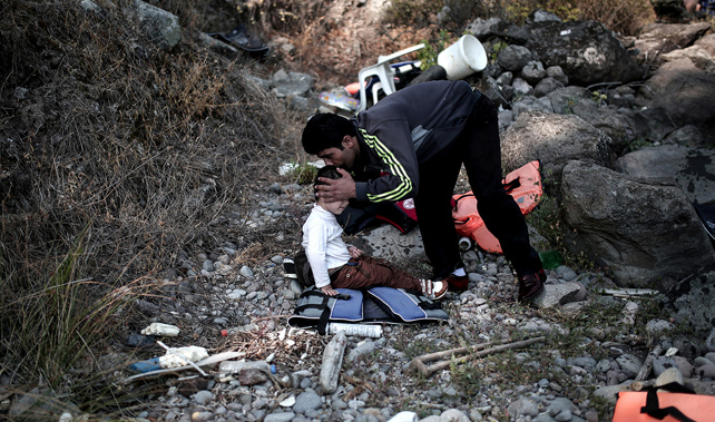 A refugee kisses his son after arriving on the shores of the Greek island Lesbos (Getty Images) 