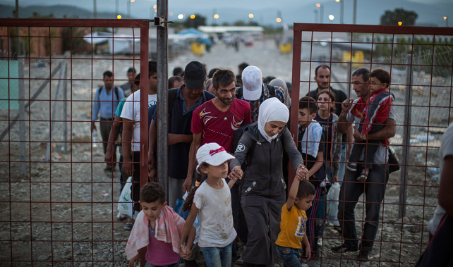 Migrant families walk out of a transit area towards in Macedonia train station to find transport to the Serbian border (Getty Images)  
