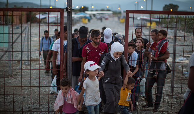 Migrant families walk out of a transit area towards in Macedonia train station to find transport to the Serbian border (Getty Images)