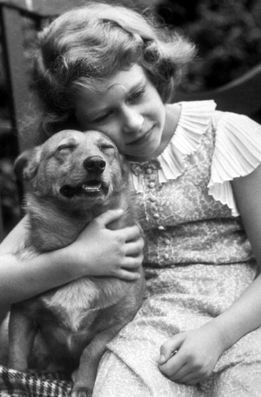 July 1936: Princess Elizabeth hugging a corgi dog