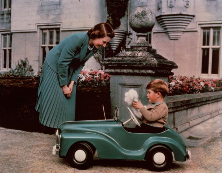 28th September 1952: Princess Elizabeth watching her son Prince Charles playing in his toy car while at Balmoral