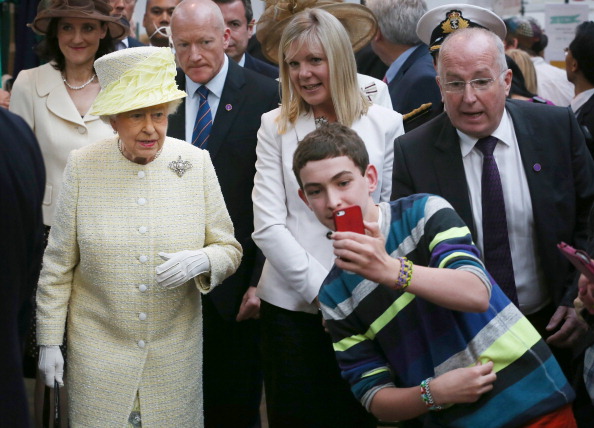 A local youth takes a selfie photograph in front of Queen Elizabeth II, 2014