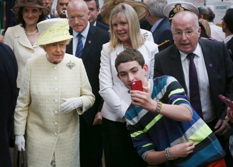 A local youth takes a selfie photograph in front of Queen Elizabeth II, 2014