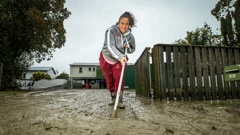 Wairoa resident Libby Young cleaning up her flooded property. Photo / Paul Taylor