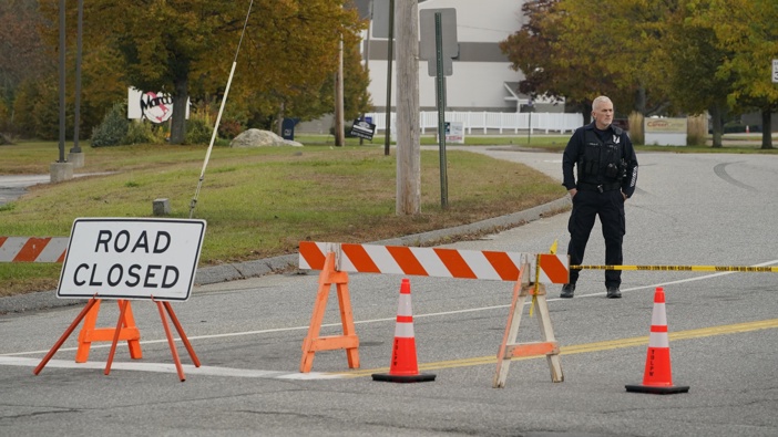 A police officer stands at a road closure near a bowling alley, seen in background, Thursday, Oct. 26, 2023, in Lewiston, Maine. Photo / AP