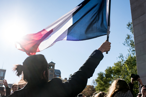 A woman in New York holds French flag aloft at supprt rally