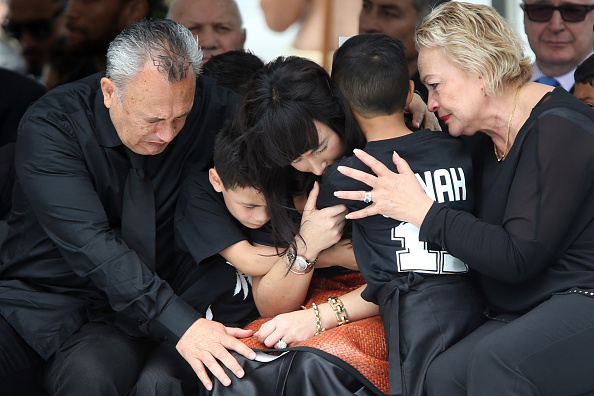 Nadene Lomu (C) is comforted by her two sons, Brayley (centre L) and Dhyreille (centre R), and her mother Lois Kuiek (R) and father Mervyn Kuiek (L)