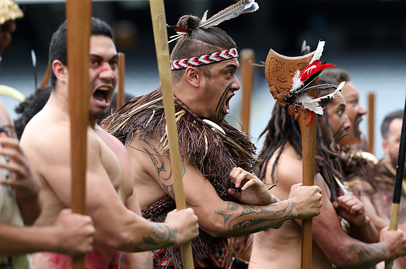 Maori warriors perform a haka as the casket is carried onto the field