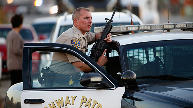 An armed police officer stands watch following a mass shooting in California (Getty Images)