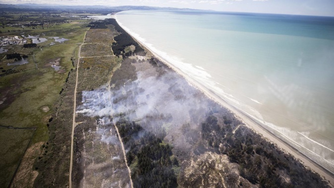 Helicopters and planes were brought in to help fight the large scrub fire at Woodend Beach. Photo / George Heard