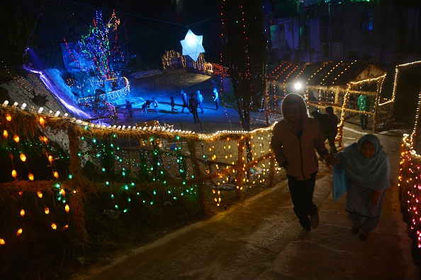 Pakistani people walk past Christmas decorations in Islamabad. 