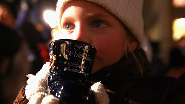 A girl sips hot chocolate at a Christmas market in Munich, Germany. 
