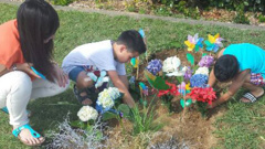Nadene Lomu and her two sons place flowers on Jonah Lomu's grave at Manukau Memorial Gardens.