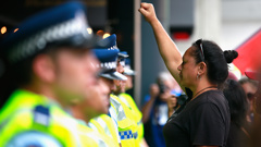 An anti-TPP protester confronts the police guarding the Sky City Convention Centre where the free trade deal was being signed on February 4, 2016 (Getty Images) 