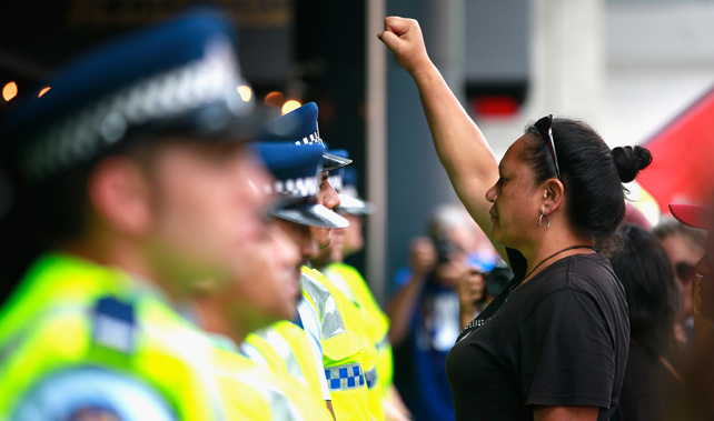 An anti-TPP protester confronts the police guarding the Sky City Convention Centre where the free trade deal was being signed on February 4, 2016 (Getty Images)