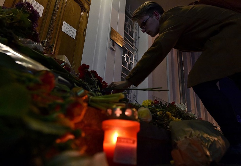 A man places flowers outside the Belgian embassy in Moscow.