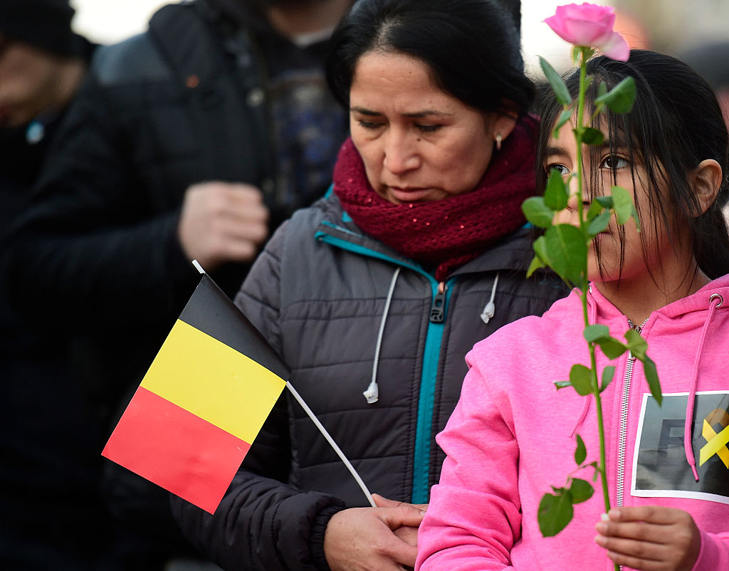 A local woman holds a paper national flag of Belgium at Beursplein Square in Brussels 