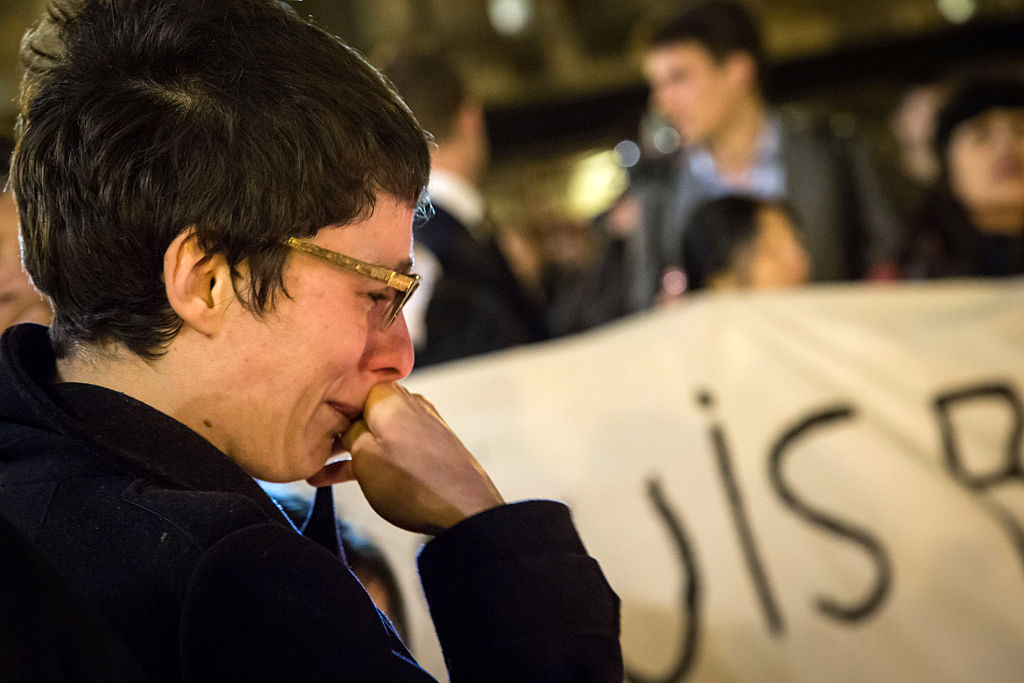 A woman cries as people gather in front of the Bourse of Brussels