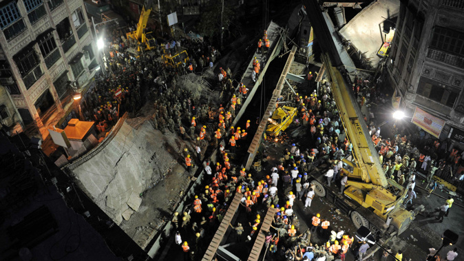 Rescue workers and volunteers try to rescue people trapped under the wreckage of a collapsed fly-over bridge in Kolkata, India. (Getty Images)