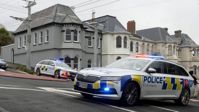 Police gather at the location of an attempted shooting at the corner of Manor Pl and Melville St in Dunedin yesterday. Photo / Gerard O'Brien