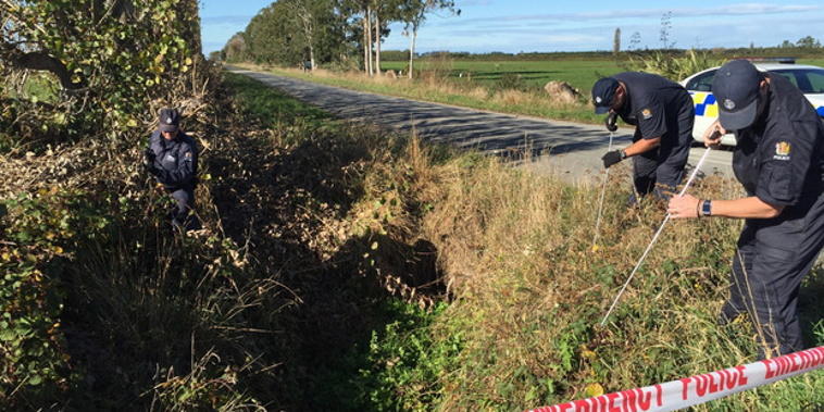 Investigators search the scene (NZ Herald)