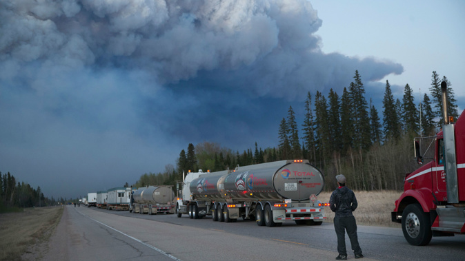Drivers wait for clearance to take firefighting supplies into town outside of Fort McMurray, Alberta. (Photo / Getty Images)