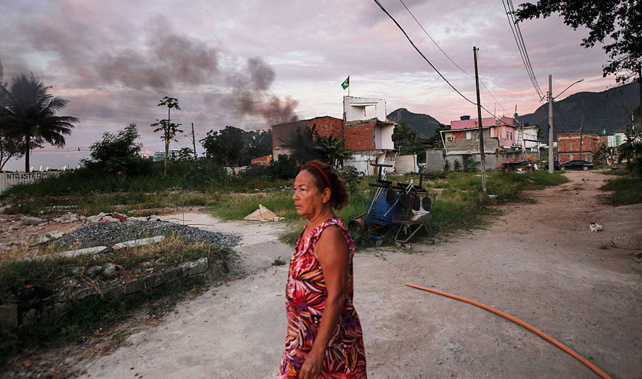 A woman, who has been diagnosed with Zika virus, walks through Vila Autodromo, a favela which has been forcibly demolished to make way for the Olympics (Getty Images) 