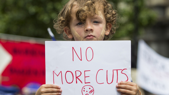A child in Britain holding a sign at a protest against education cuts (Getty Images)