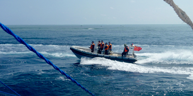 In this file photo from October 2015, a Chinese Coast Guard boat circles a Filipino fishing boat near Scarborough Shoal in the South China Sea. Photo / AP / NZ Herald