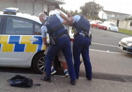 Police detain a suspect after a mass brawl at a Mangere KFC (Facebook)