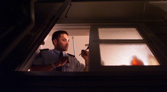 Constable Vaughan Perry tries to get prints from a window sill in Mt Albert. (Peter Meecham, NZ Herald)